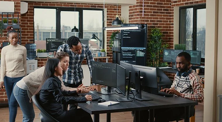 Two people standing around a computer