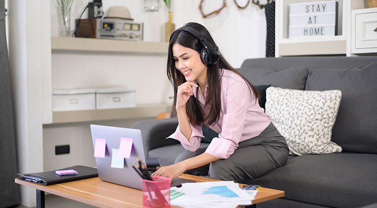woman in pink blouse in front of a laptop