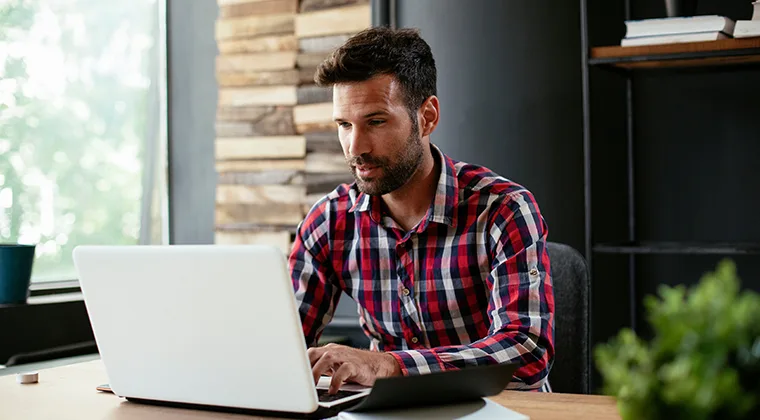 Man in red plaid shirt at laptop